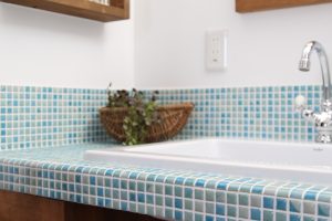 洗面カウンターは爽やかなブルー系のモザイクタイル。